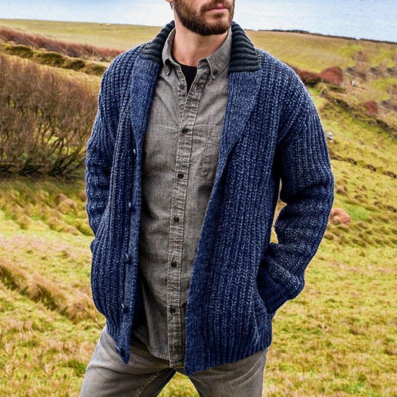 Mann in blauer Strickjacke und grauem Hemd in ländlicher Landschaft, Herbstmode Herren.