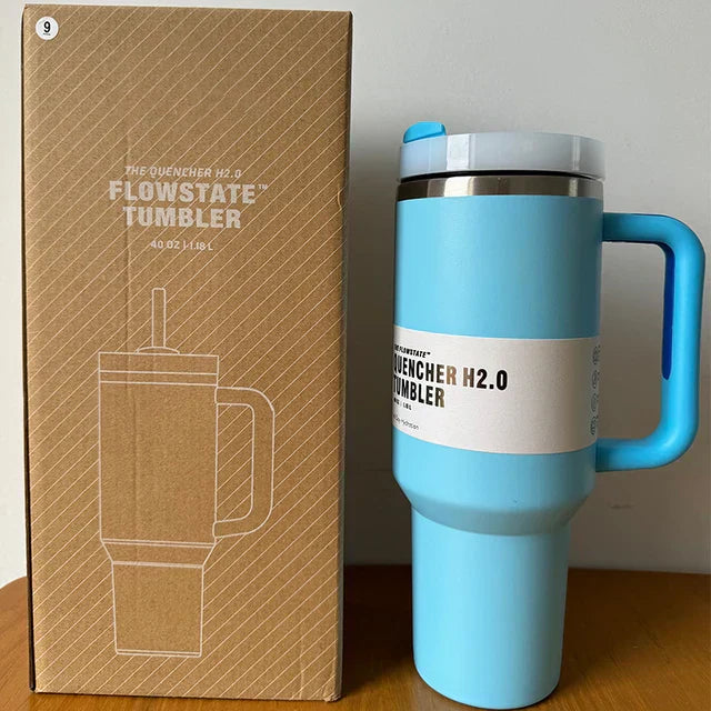 Blaue Flowstate Tumbler 40oz mit Griff, Edelstahl, isoliert, neben Verpackung.
