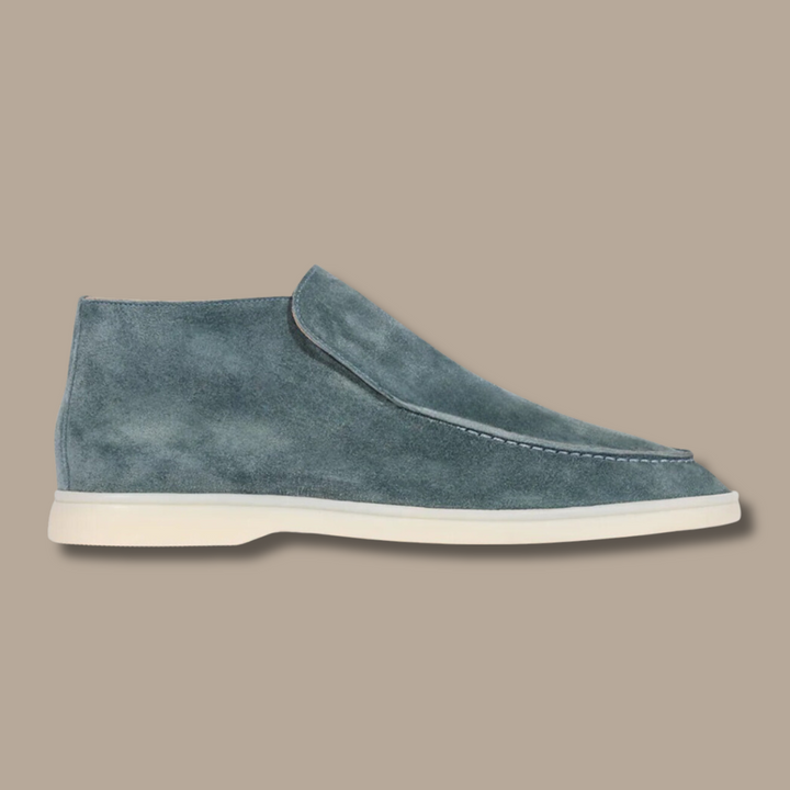 Blauer Wildleder-Herrenschuh, knöchelhoch, mit weißer Sohle, elegantes Design.