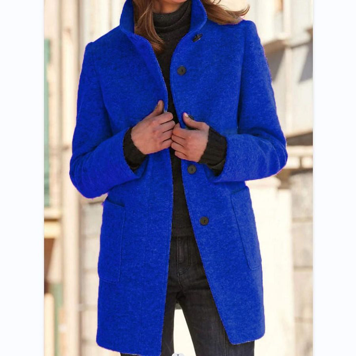 Frau in blauem Wollmantel, schwarze Jeans, Herbstmode, stilvoll, urbaner Hintergrund.