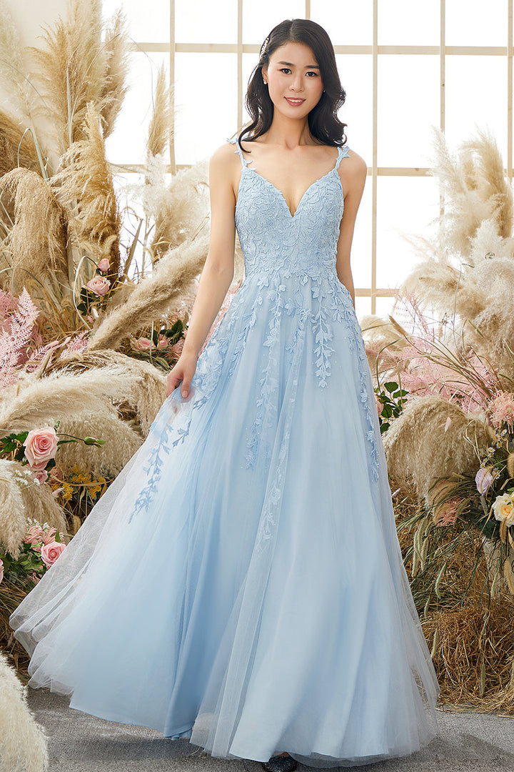 Frau im hellblauen Abendkleid mit Spitzen, vor Fenster und Pampasgras, elegantes Design.