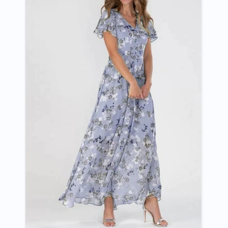 Frau in langem, blumigem, blauem Sommerkleid mit kurzen Ärmeln und V-Ausschnitt.