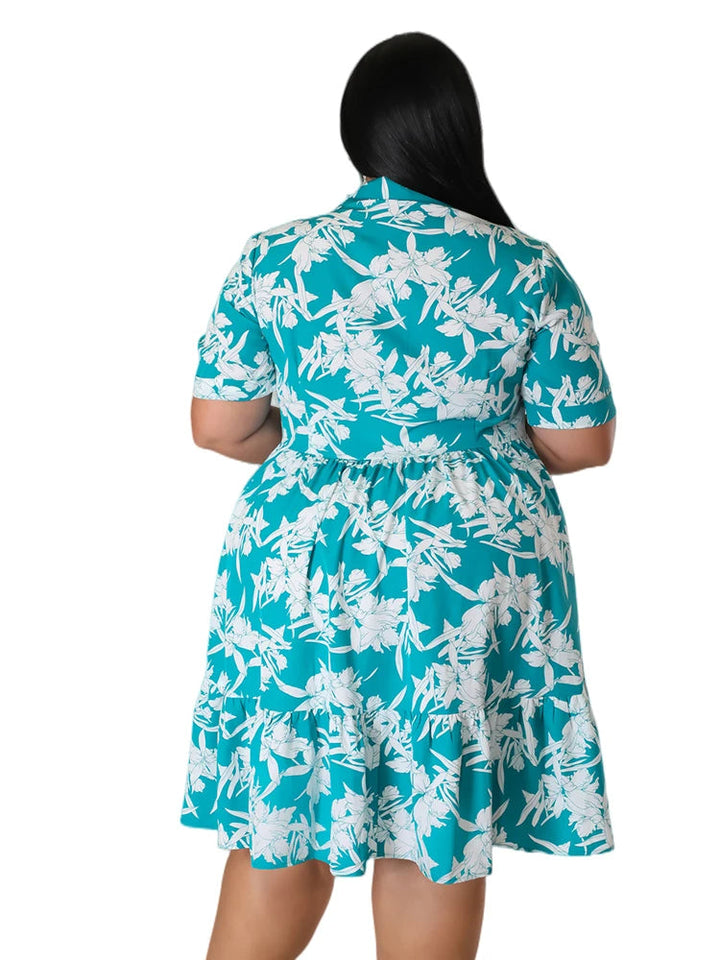Frau in türkisfarbenem, geblümtem Sommerkleid, Plus-Size-Mode, Rückansicht.