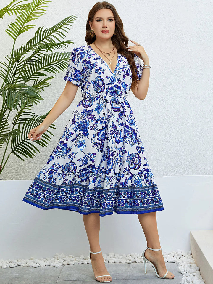 Frau im blauen Blumen-Sommerkleid, V-Ausschnitt, knielang, elegante Mode, draußen.