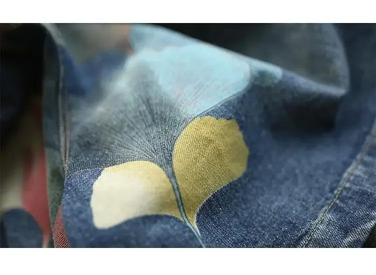 Nahaufnahme bedruckter Jeansstoff mit gelbem und blauem Blumenmuster, modisch, hochwertig.