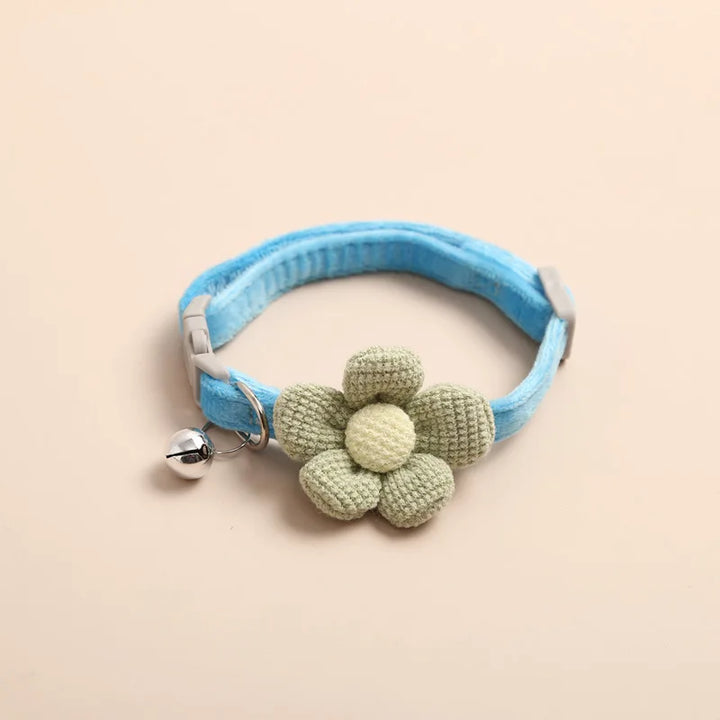 Hellblaues Katzenhalsband mit grüner Stoffblume und Glöckchen, Haustierzubehör.