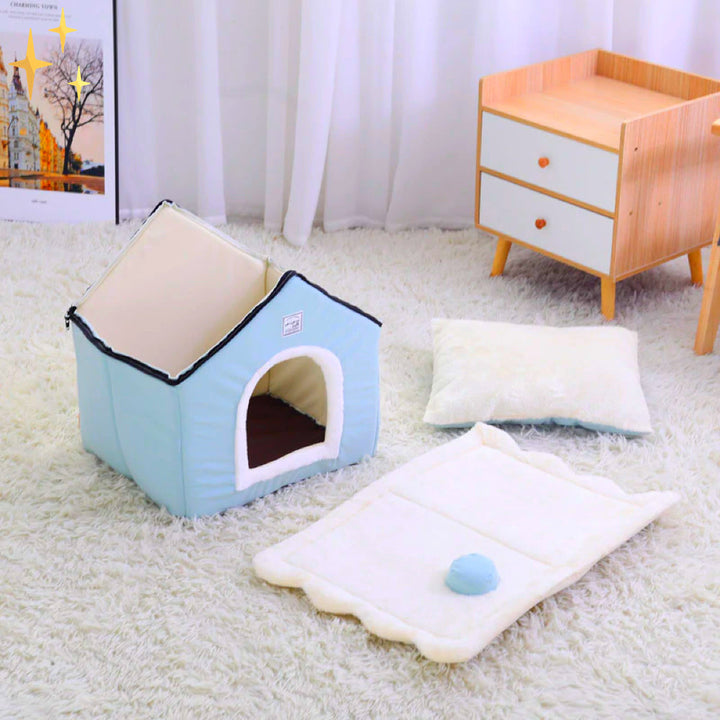 Blaue Hundehütte aus Stoff auf weißem Teppich, mit Kissen und Spielzeug, modernes Design.