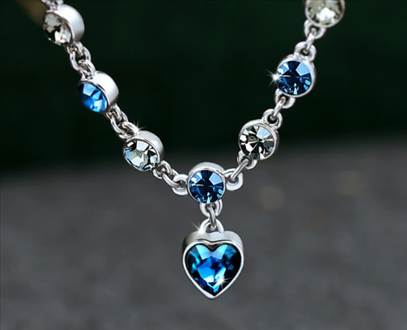 Silberne Halskette mit blauen und klaren Kristallen, Herzanhänger, eleganter Schmuck.