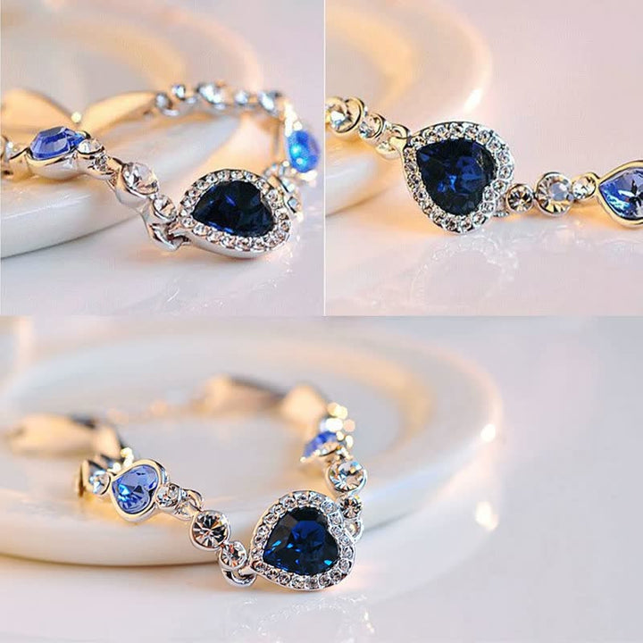 Silberarmband mit blauen Herzanhängern und Kristallen, eleganter Schmuck für Damen.