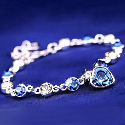 Silberarmband mit blauen Kristallen und Herzanhänger, eleganter Schmuck, Damenaccessoire.