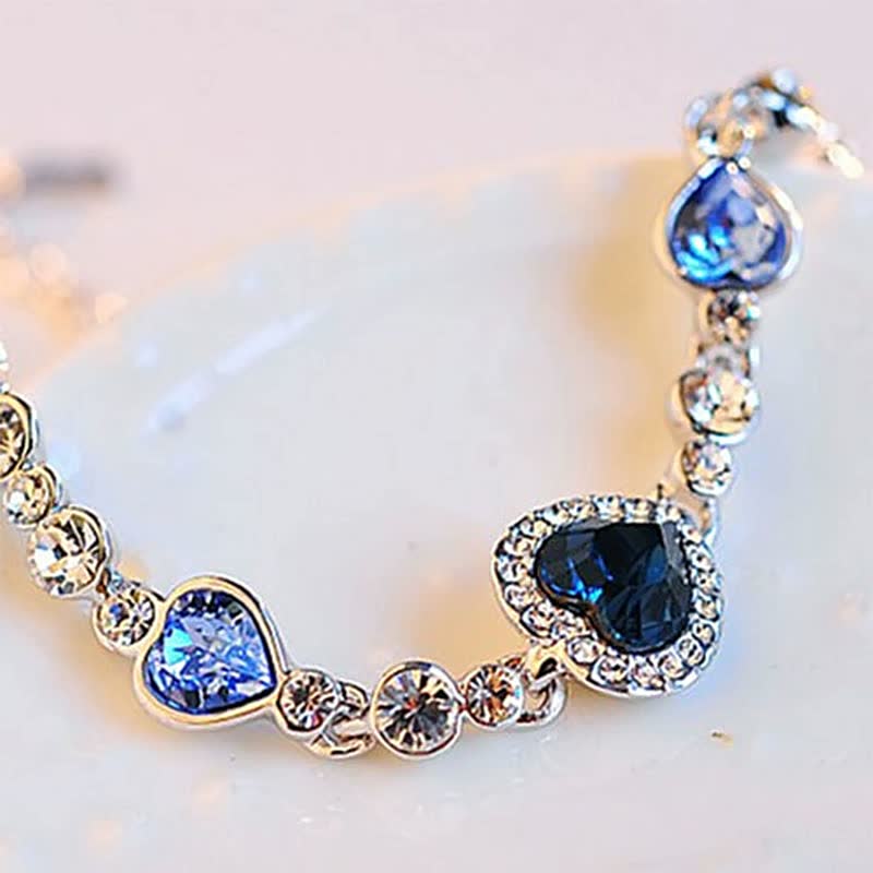 Silbernes Armband mit blauen Herzanhängern und Kristallen, eleganter Schmuck für Damen.
