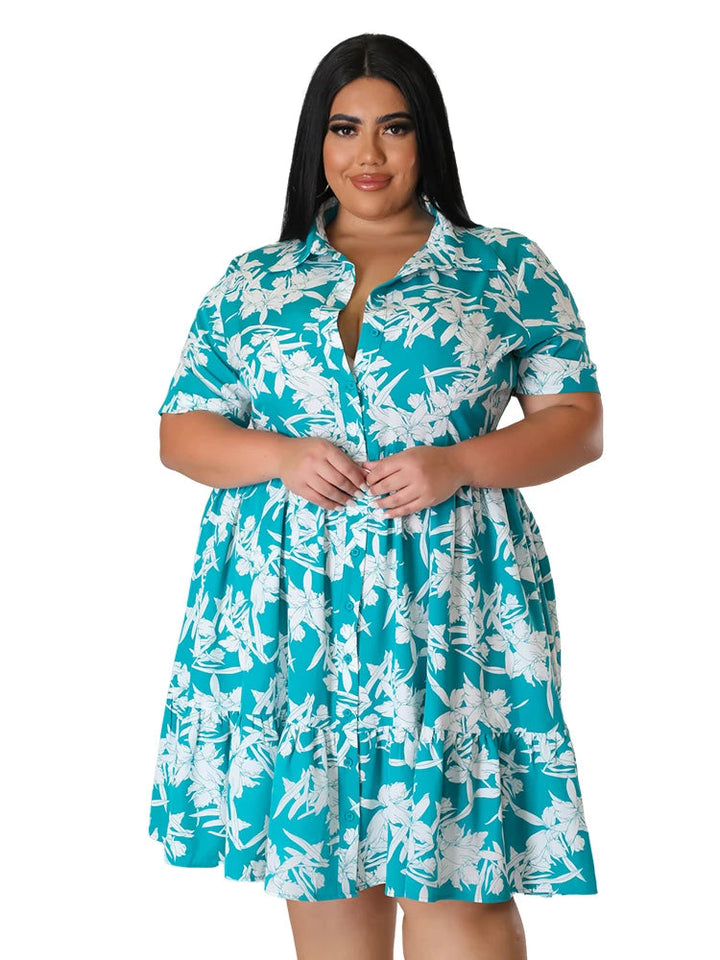 Frau in türkis-weißem Sommerkleid mit Blumenmuster, Plus-Size-Mode, Kurzarm, Knopfleiste.