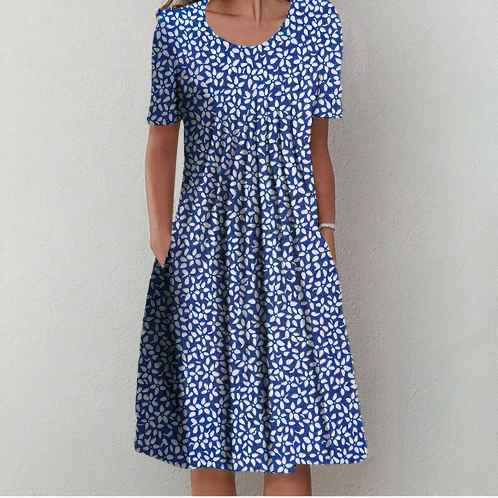 Blaues Sommerkleid mit weißem Blumenmuster, knielang, kurzärmelig, aus Baumwolle.