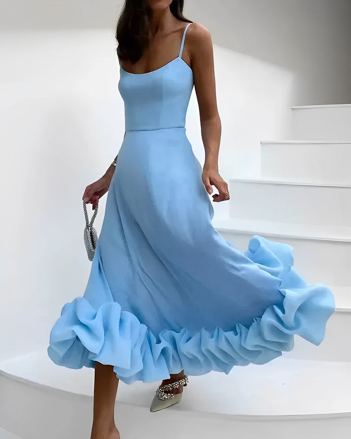 Frau in hellblauem Abendkleid mit Rüschen, silberne Clutch, elegante Mode, Treppe.