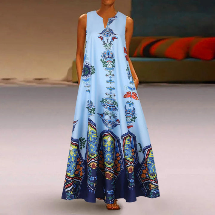 Frau in langem, blauem Sommerkleid mit buntem Paisley-Muster im Wohnzimmer.