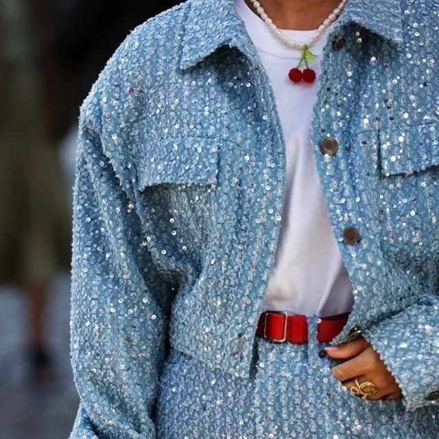 Blaue Paillettenjacke und Rock, roter Gürtel, weiße Bluse, Kirschkette, Damenmode.