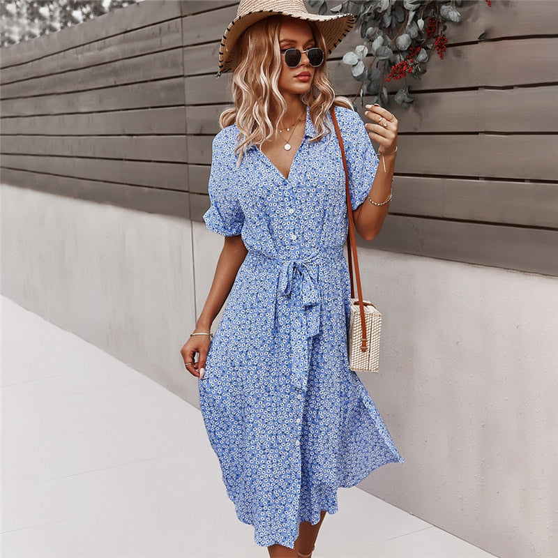 Frau in blauem Sommerkleid mit Strohhut und Sonnenbrille, modisch, lässig, draußen.