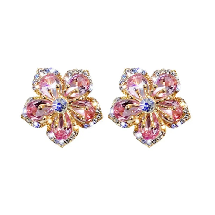 Goldene Blumenohrringe mit rosa Kristallen, funkelnd, eleganter Schmuck, Damenaccessoire.