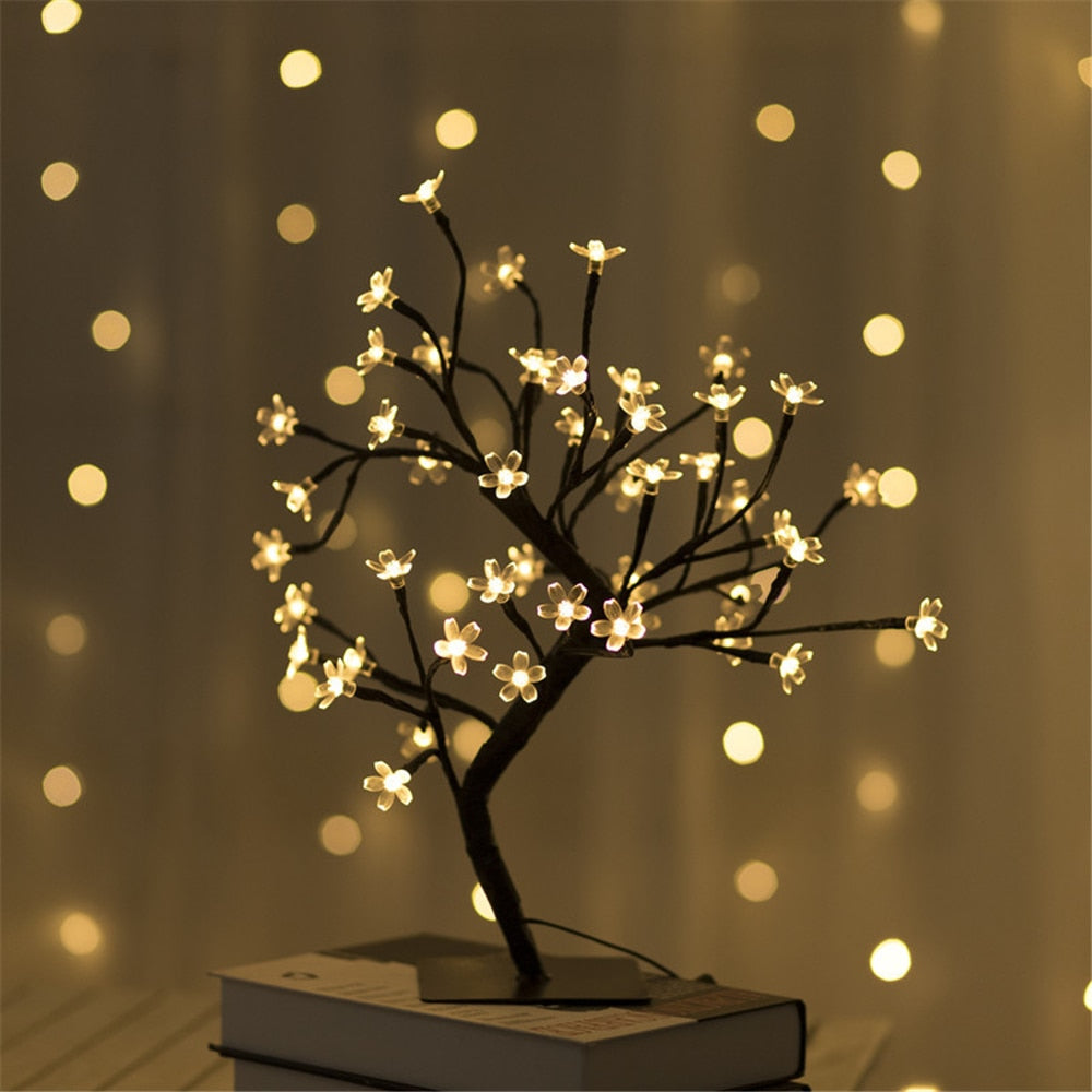 LED-Baumlampe mit warmweißen Blütenlichtern, dekorative Beleuchtung, stimmungsvoll, modern.