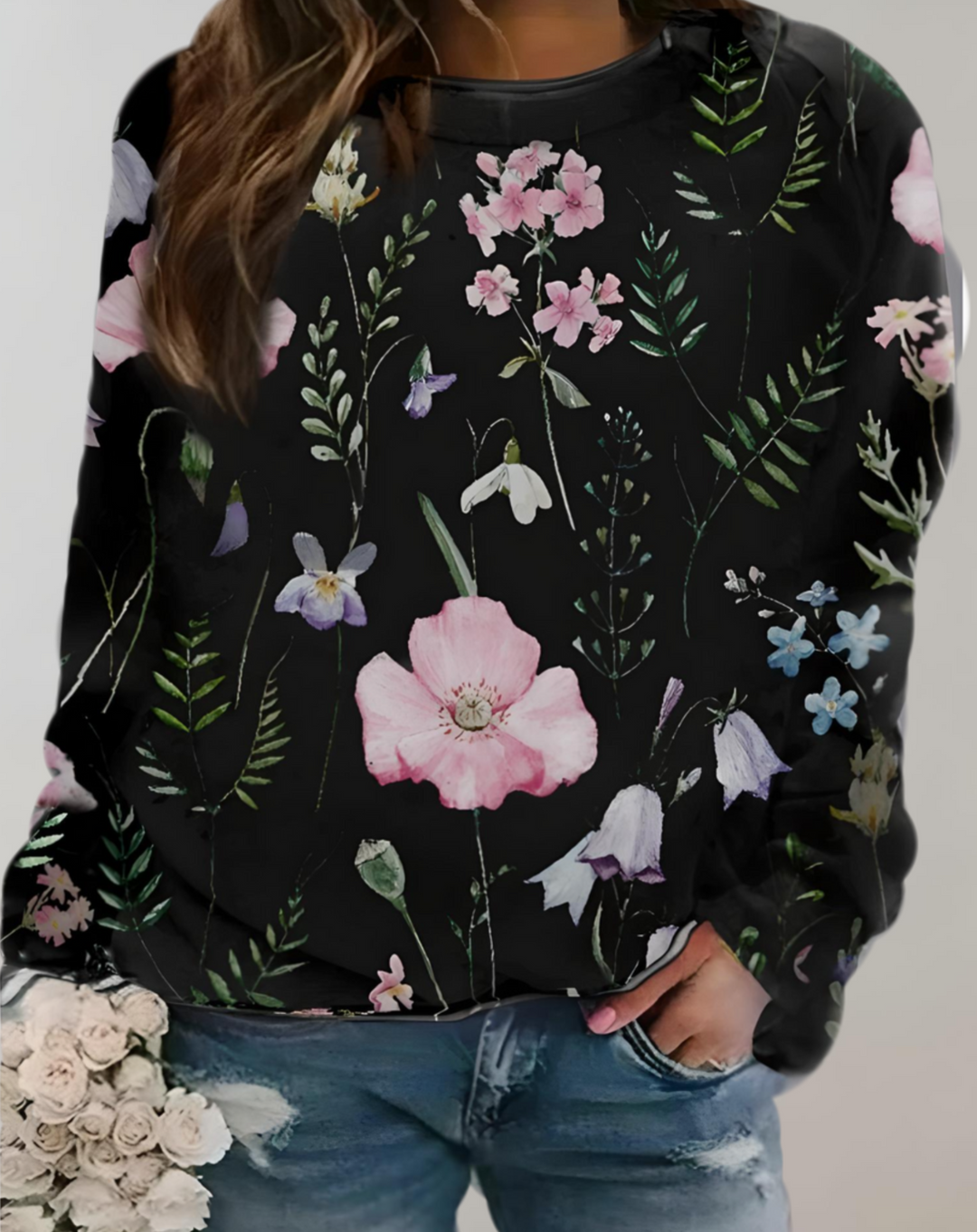 Frau in schwarzem Blumenpullover, lässige Jeans, Blumenmuster, modisch, Freizeitkleidung.