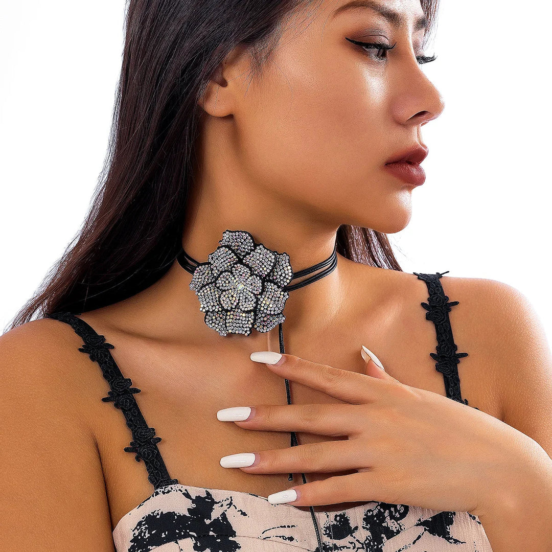 Frau mit schwarzem Choker und großer, silberner Blumenbrosche, eleganter Schmuck, Modeaccessoire.