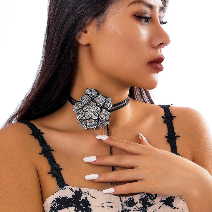 Frau mit schwarzem Choker und großer, silberner Blumenbrosche, eleganter Schmuck, Modeaccessoire.