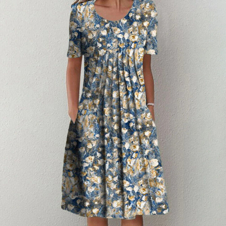 Frau in geblümtem Sommerkleid, blau-gelb, knielang, kurzärmelig, lässig, Baumwolle.