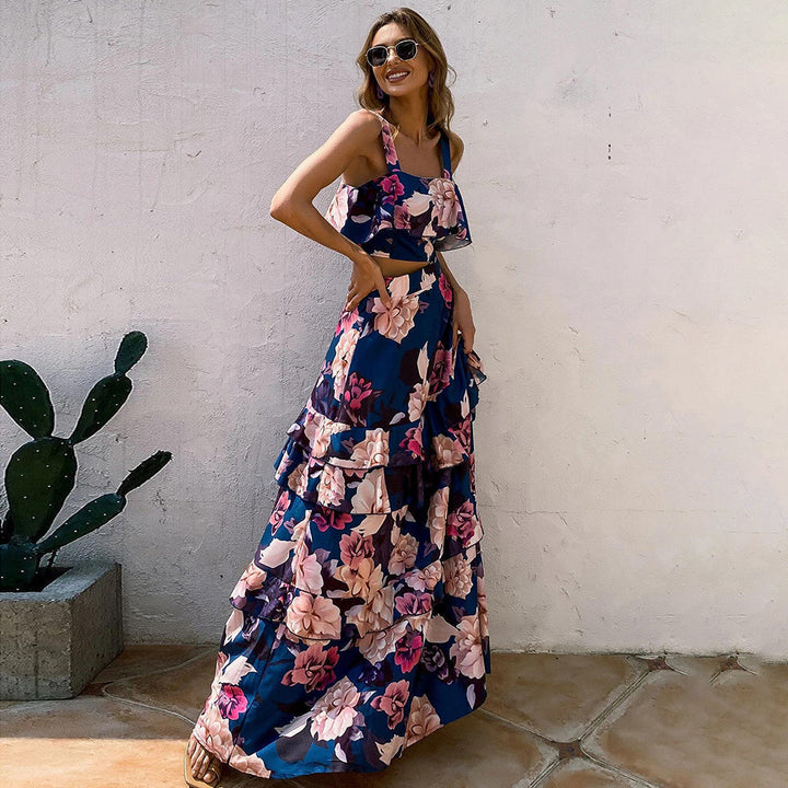 Frau in langem, geblümtem Maxikleid, blau-rosa, Sommermode, draußen, lächelnd.