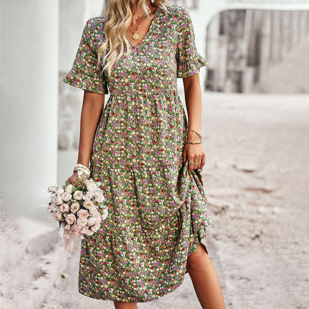 Frau in geblümtem Midikleid, hält Rosenstrauß, Sommermode, grün, elegant, Freizeitkleidung.