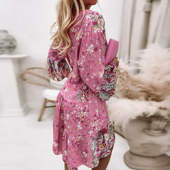 Frau in rosa geblümtem Kleid, hält rosa Clutch, modisch, elegant, Sommerkleidung, Innenraum.