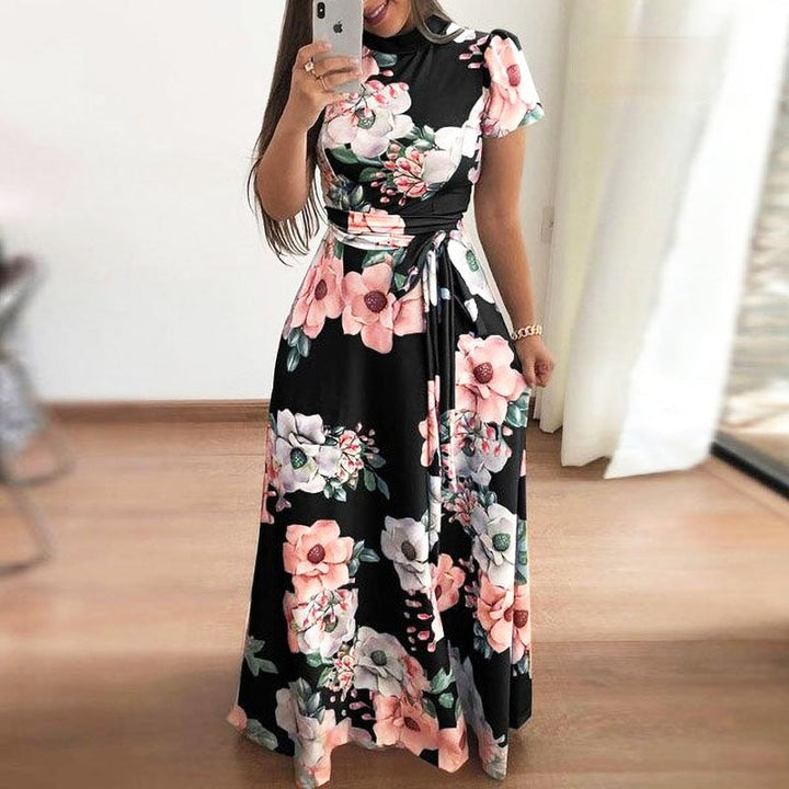 Frau in langem, schwarzem Blumenkleid mit rosa und weißen Blumenmuster, Sommermode.