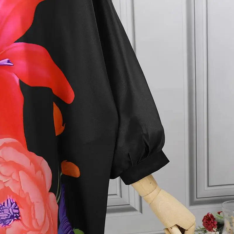 Schwarzes Seidenkleid mit buntem Blumenmuster, elegantes Design, Damenmode, Detailansicht.