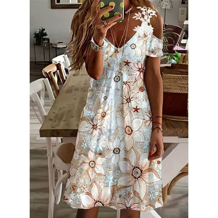 Frau in weißem Sommerkleid mit Blumenmuster, schulterfrei, lässig, modisch, im Innenraum.