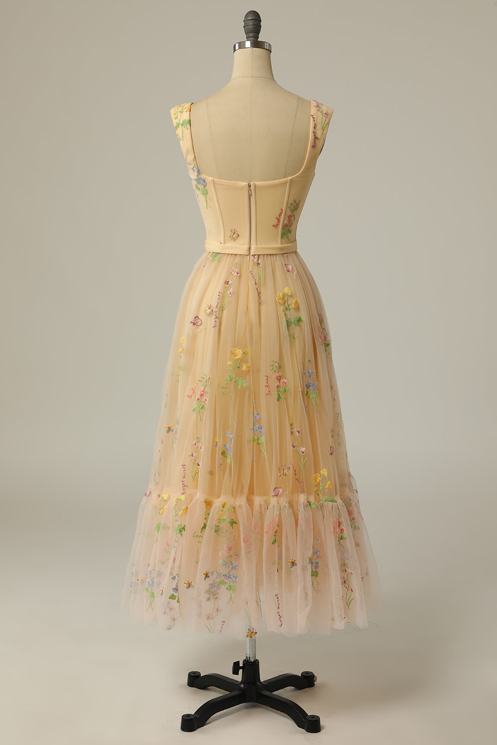 Rückansicht eines floralen, ärmellosen, langen Kleides auf Schneiderpuppe, beige mit Blumenmuster.