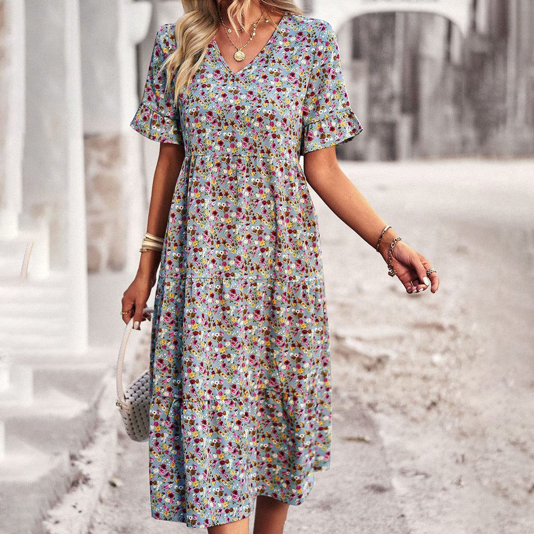 Frau in geblümtem Sommerkleid, V-Ausschnitt, blau, knielang, modisch, elegant, Freizeitkleidung.