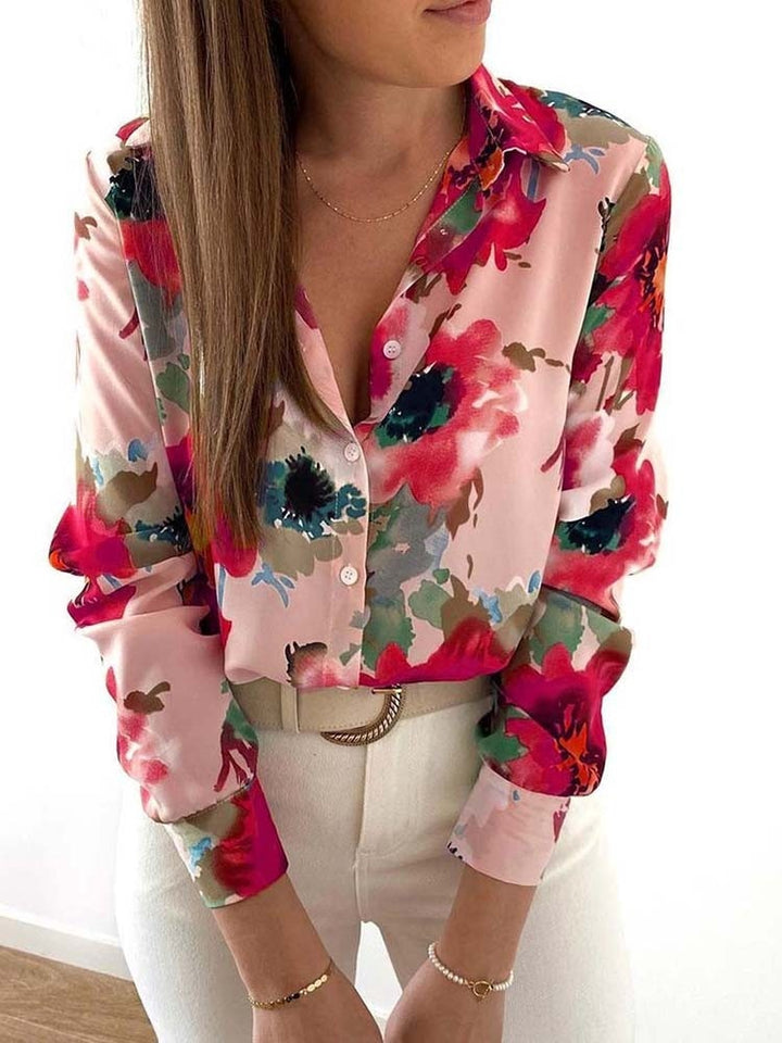 Frau trägt bunte Blumenbluse, Langarm, V-Ausschnitt, modisch, elegant, Damenmode, Frühling.