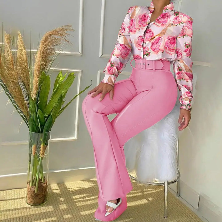 Frau in rosa Anzug mit Blumenmuster-Bluse, modische Damenbekleidung, stilvoll, ästhetisch.