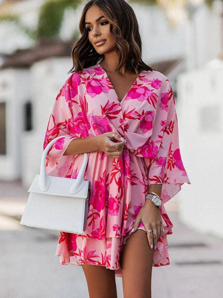 Frau in rosa Blumenkleid mit weißer Handtasche, modisch, Sommermode, elegantes Outfit.