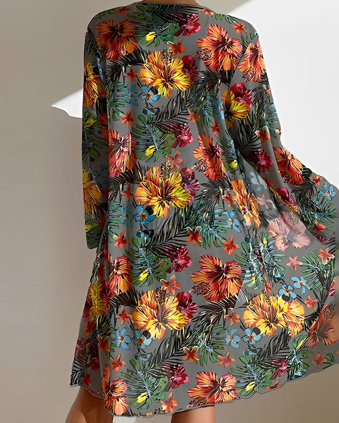 Farbintensives, florales Sommerkleid mit tropischem Muster, ideal für Strandmode.