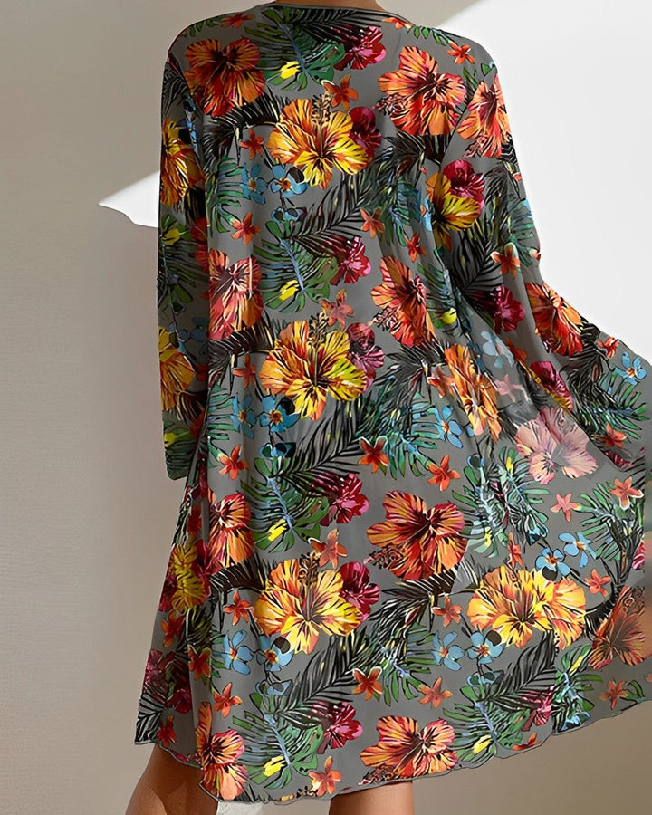 Farbintensives, florales Sommerkleid mit tropischem Muster, ideal für Strandmode.