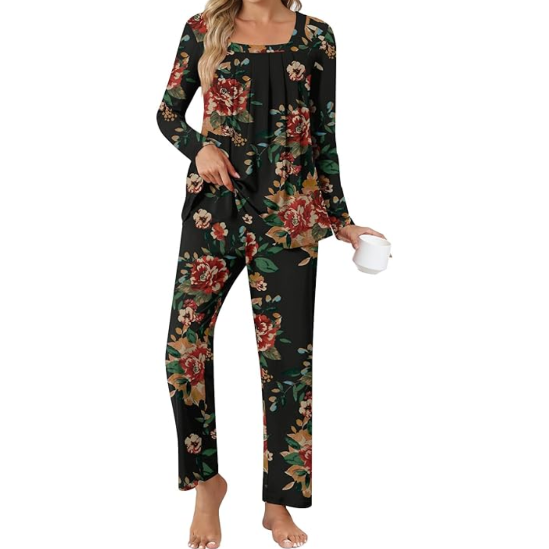 Frau in schwarzem Blumen-Pyjama, langärmelig, mit Kaffeetasse, gemütliche Nachtwäsche.