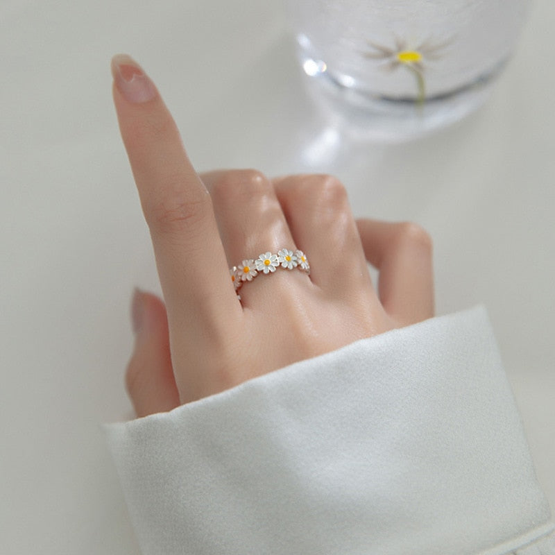 Damenring mit Gänseblümchen, Silber, Blumenmuster, eleganter Schmuck, modisches Accessoire.