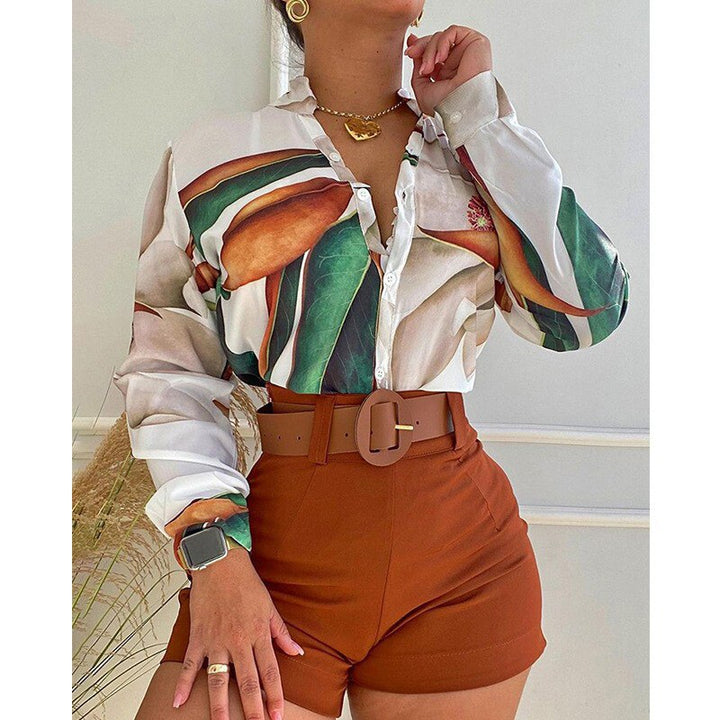 Frau in weißer Bluse mit Blattmuster und braunen Shorts, modisch, elegant, Sommeroutfit.