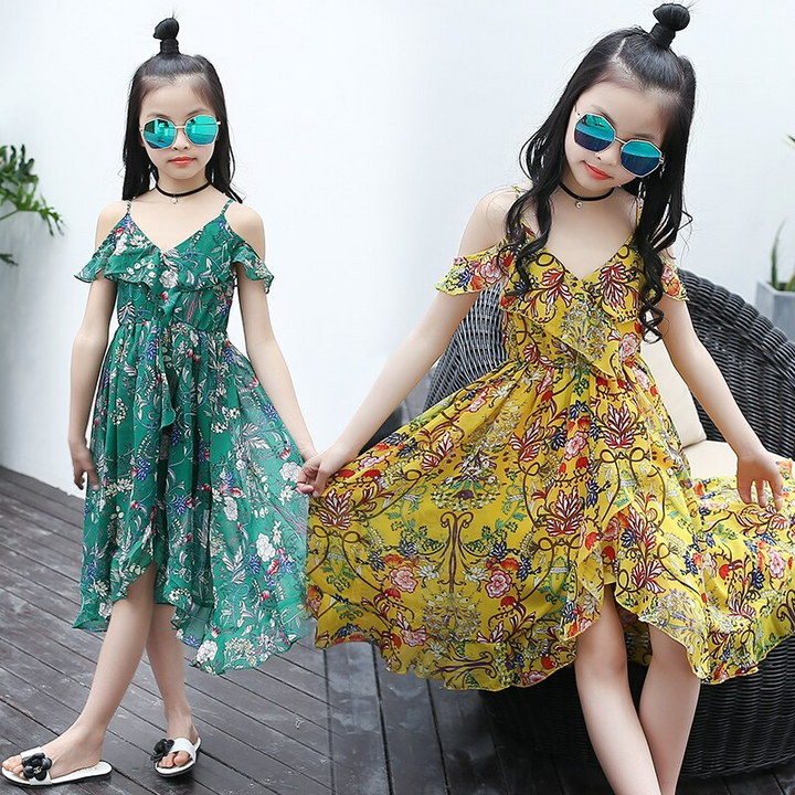 Zwei Mädchen in Boho-Sommerkleidern, grün und gelb, mit Blumenmuster und Sonnenbrillen.