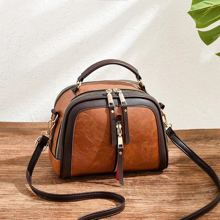 Braune Lederhandtasche mit Schulterriemen auf Holztisch, modisches Accessoire für Damen.