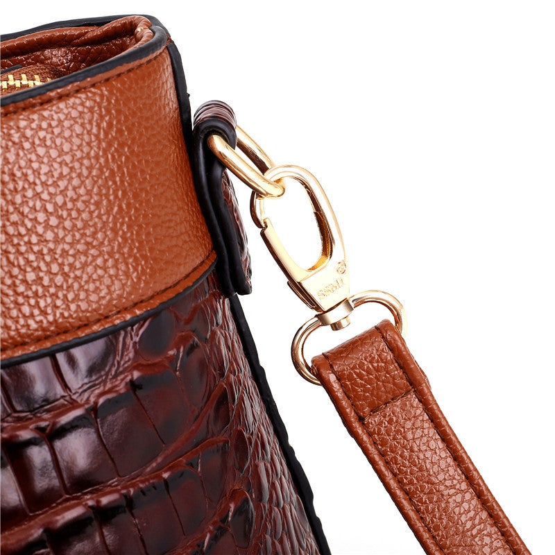 Braune Lederhandtasche mit Krokodilleder-Optik und goldener Metallschnalle.