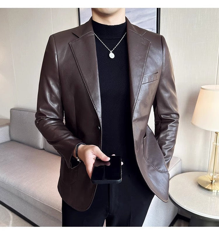 Mann im braunen Lederblazer, schwarzes Hemd, Smartphone, elegantes Outfit, modernes Wohnzimmer.