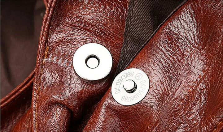 Braune Lederjacke mit silbernem Druckknopf, hochwertige Mode, stilvolles Design.
