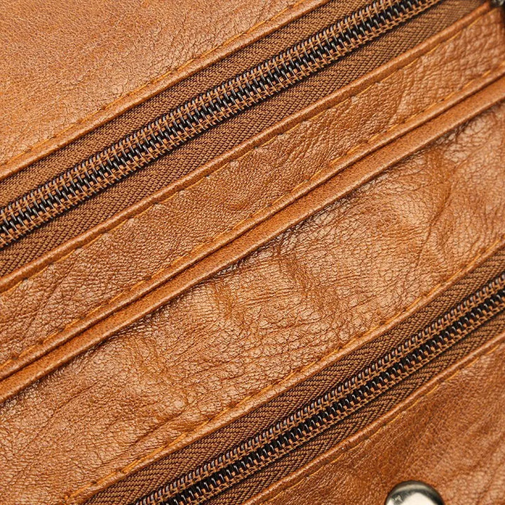 Braune Ledertasche mit Reißverschlüssen, hochwertiges Material, stilvolles Accessoire.