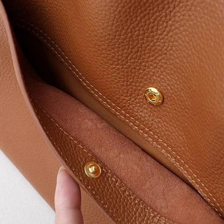 Braune Ledertasche mit goldenen Druckknöpfen, Nahaufnahme, hochwertige Handtasche.
